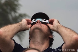 Man with eclipse glasses looking up